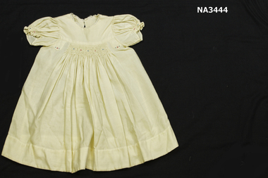 Cream viyella dress with smocked bodice and sleeves, with pink and blue rosebuds. 