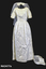 1963 Wedding dress of cream satin; floor length, short sleeves, round neckline, fitted at waist.