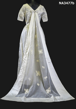 1963 Wedding dress of cream satin; floor length, short sleeves, round neckline, fitted at waist. 