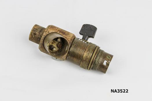A round cylinder of wood and brass with small handle/toggle on side and side outlet. 