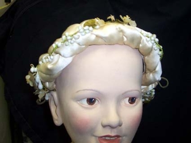 Cream satin from wedding twisted and held on to head band. 