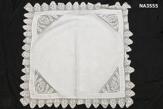 White linen square with corner inserts of lace.
