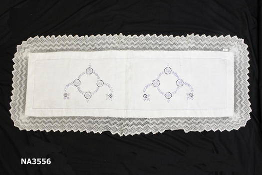 Fine white linen table runner embroidered in mauve silk flowers and cut work. 
