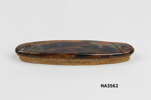 Oval tortoiseshell case containing four manicure tools with tortoiseshell handles.