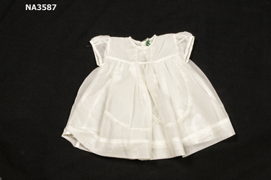 1964 white terylene dress, puff sleeves gathered at bodice and trimmed with nylon lace from neck edge to skirt. 