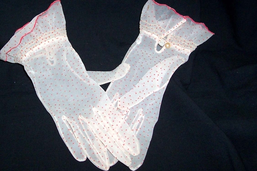 A pair of probably 1950s gloves in sheer nylon with red spot. 