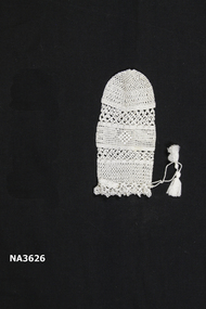White cotton crochet cover with ties and tassels at neck edge