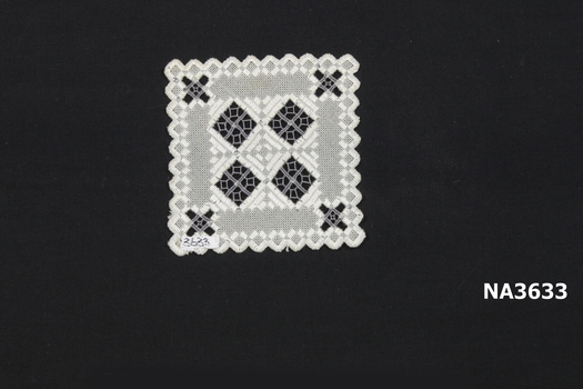 A square mat scalloped at edge worked in cream and grey