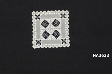 A square mat scalloped at edge worked in cream and grey
