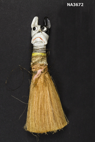 Yellow horse hair bristles attached to china ornament in the shape of a dog's head. 