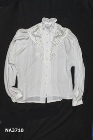 White blouse with lace inset and pin tucks.