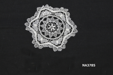 Physical description  White cotton bobbin lace round doyley with concentric separate patterns