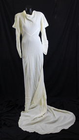 1936 cream seersucker dress featuring a cowl neck and long sleeve, slit at shoulder to create cowl effect.