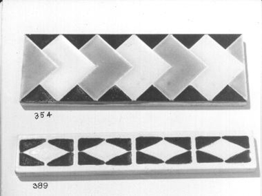 White glazed border tile with black triangles forming squares with white diamonds in centre.