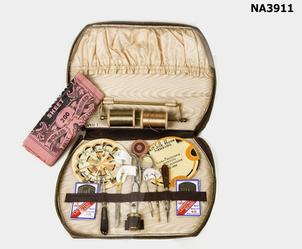 Brown leatherette case containing ladies' sewing kit.