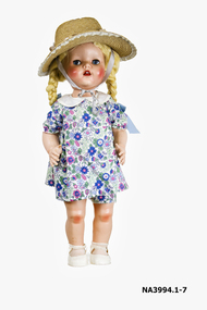 A walking doll A child's doll resembling a small child dressed in summer clothes and a straw hat,