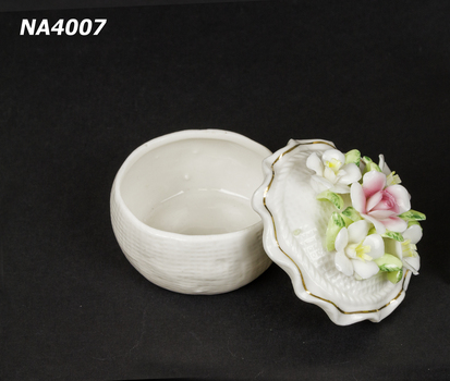 Cream china dish, with fluted lid and five china flowers and leaves arranged on top of lid.