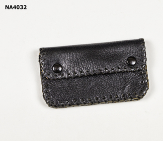 Black leather purse with black leather thonging around edges.  