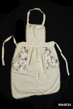Cream calico bib apron.  Floral trim across top of bib.