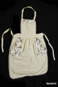 Cream calico bib apron.  Floral trim across top of bib.