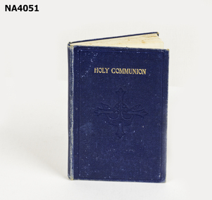 Blue covered Holy Communion book 'Holy Communion' in gold.  Imprint of crown and cross and BISHOP HOW on front. 