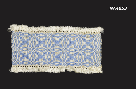 Cream and blue woven place mat with cream fringe