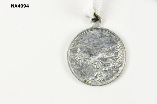 Possibly Aluminium Alloy with shank to hold ribbon or chain.