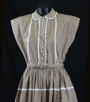 Detail of front of light brown poplin day dress. 