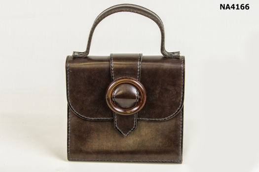 Small brown leather handbag.  Short handle with round buckle on front.  
