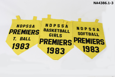 Three yellow felt pennants with black writing year 1983.