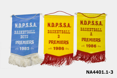 Yellow plastic with red writing and red fringing and red cord for hanging. 