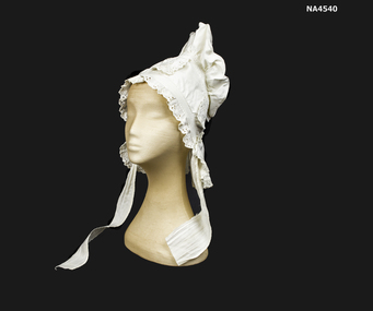White cotton bonnet decorated with embroidered Anglais and trimmed around face and hem. 