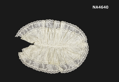 Creamy white lace jabot of two gathered layers into an oval shape with centre of five lace flowers down the front.