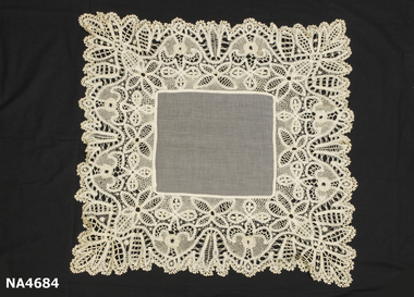 Cream square tablecloth edged in hand made tape lace with hand crocheted edge.