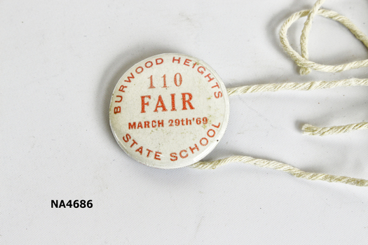 Small round white coloured badge with red printing: