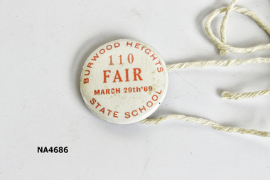 Small round white coloured badge with red printing: