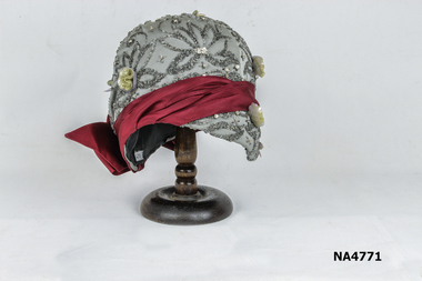 Grey jewelled hat with maroon bow. 