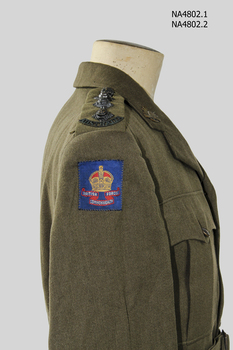 Khaki army woollen jacket with belt which has a metal buckle, rising sun badge on each lapel.