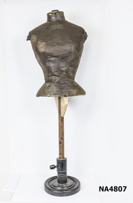 Dark brown torso length mannequin with wooden base and neck and arm holes. 
