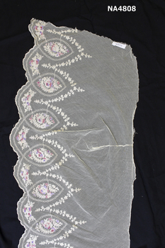Length of embroidered lace on a background of cream net. 