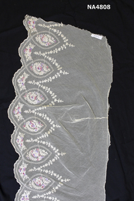 Length of embroidered lace on a background of cream net. 