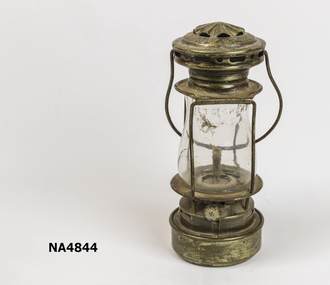 Small hurricane lamp with metal top and base and glass lantern.