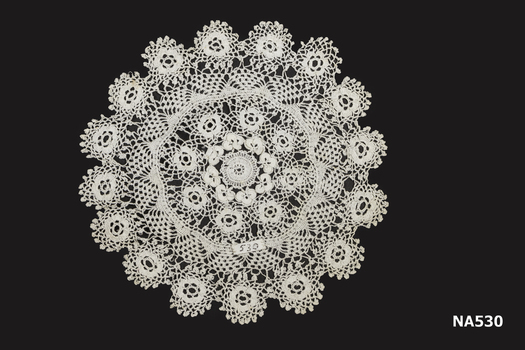 White crochet doyley.  This is part of a set of three. See Na 500 and 550.