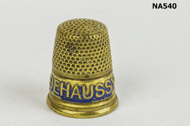 Brass sewing thimble.