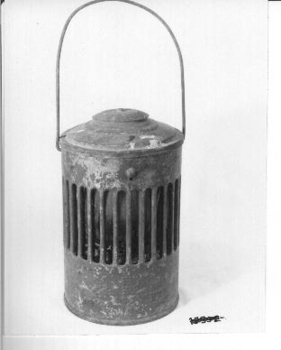 Red painted outer case with lid. Inner red glass lamp and kerosene holder with wire to lift out for filling. 