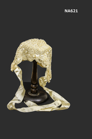Baby's Cream bonnet crocheted with rayon lined with silk and threaded with cream ribbon. 