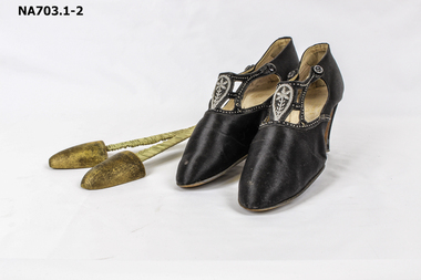 Black satin shoes with seed pearl decoration across the instep and buttoned on sides.
