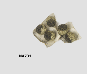 Five small crocheted balls with black and gold thread on top half and grey thread on bottom