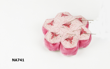 Pink patchwork pincushion with darker pink pattern and sides.