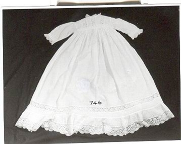 White lawn infant's dress with torchon lace on neck, bodice, hem of sleeves and dress .
